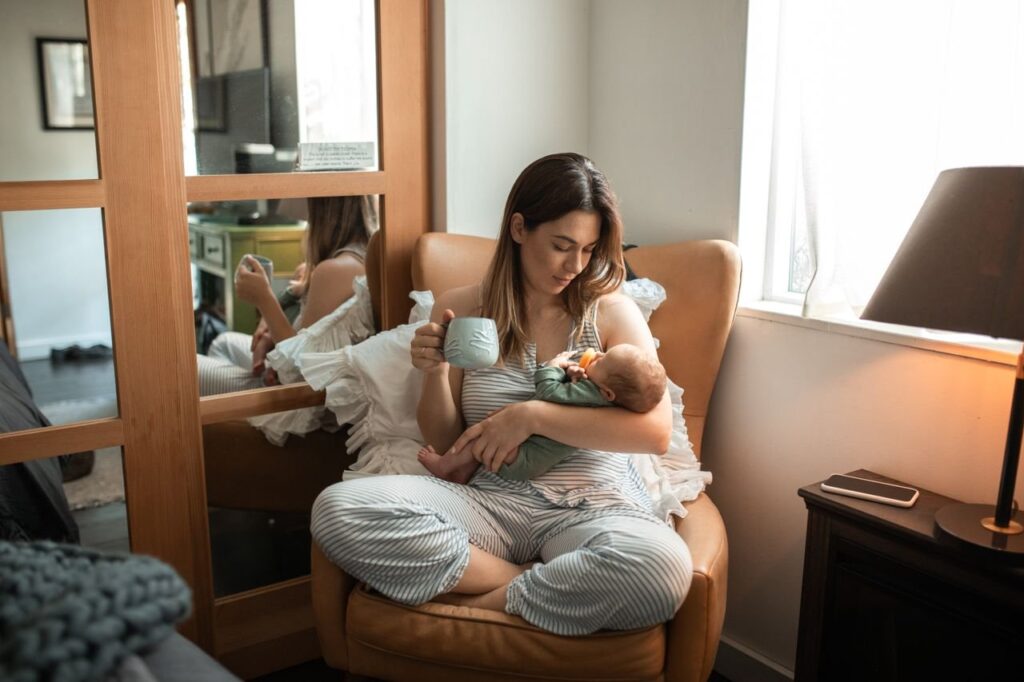 Jonge moeder voedt haar baby tijdens het herstel na de bevalling